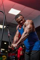muskulös stark Mann Arbeiten schwer im das Fitnessstudio. gut aussehend sportlich Bodybuilder Arbeiten mit mächtig Waffen. foto
