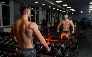 muskulös mit nacktem Oberkörper Mann Ausbildung im das Fitnessstudio. stark Bodybuilder mit sportlich Muskeln. foto