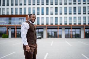 stilvoll gut aussehend Mann Gehen draussen. modisch männlich Modell- im passen Gehen auf das Straße. foto