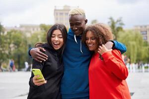 glücklich vielfältig freunde mit Smartphone im Stadt Park foto