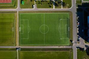 oben Aussicht von ein Fußball Feld mit Grün Gras draußen im Sommer- foto