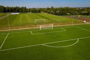 oben Aussicht von ein Fußball Feld mit Grün Gras draußen im Sommer- foto