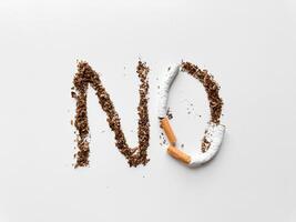 Wort 'NEIN' erstellt mit Tabak und gebrochen Zigarette auf Weiß Hintergrund zum Anti Rauchen und Gesundheit Konzept. Nein Tabak Tag. foto