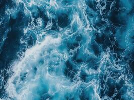 oben Aussicht von Ozean Wellen aufgewühlt mit Schaum, Erstellen kompliziert Muster von Weiß und tief Blau, dynamisch Wasser Textur. Marine Hintergrund. ai Generation foto