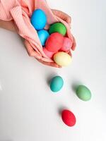 Hände Wiegen Sammlung von hell farbig Ostern Eier im Rosa Stoff, hervorrufen Themen von Ostern Traditionen, Familie Spaß, und Frühling Kunsthandwerk. foto