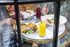 Person Sitzung beim Tabelle mit Teller von Essen foto