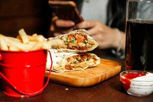 Person Sitzung beim Tabelle mit Essen und Zelle Telefon foto