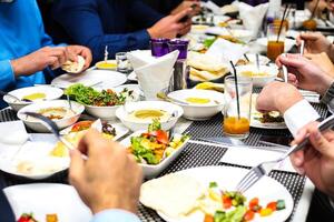 Gruppe von Menschen genießen ein Mahlzeit zusammen beim ein Tabelle foto