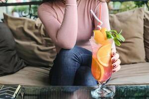 Frau Sitzung auf Couch, halten trinken foto