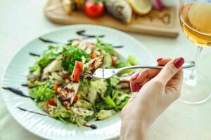 Frau Essen Salat mit ein Gabel foto