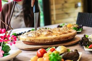 Person Schneiden Kuchen auf hölzern Tabelle foto