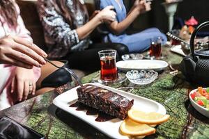 Menschen Sitzung um Tabelle mit ein Teller von Essen foto