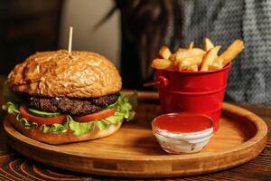 Hamburger und Fritten auf ein hölzern Tablett foto