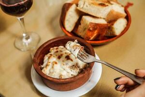 Schüssel von Essen und Glas von Wein auf Tabelle foto