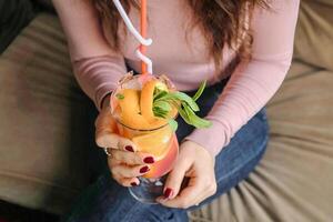 Frau Sitzung auf Couch halten ein trinken foto