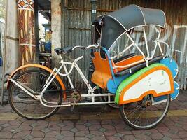 Surakarta, zentral Java, Indonesien April 11, 2024. Jahrgang becak Fahrzeug ist ein traditionell Öffentlichkeit Transport von Indonesien. foto