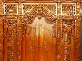 das Schönheit Kunst von ein traditionell javanisch Teak geschnitzt Tür. Menschen namens es ein gebyok Tür. foto