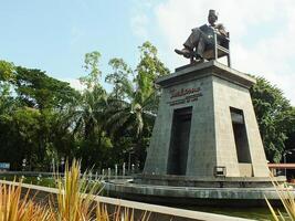 Surakarta, zentral Java, Indonesien April 11, 2024. das Statue von Herr Soekarno Sitzung während lesen ein Buch, Statue von das zuerst Präsident von das republik Indonesien beim Mann Stadion. foto