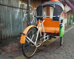 Surakarta, zentral Java, Indonesien April 11, 2024. Jahrgang becak Fahrzeug ist ein traditionell Öffentlichkeit Transport von Indonesien. foto