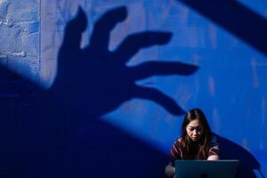 Frau konzentriert auf ihr Laptop unter ein groß Schatten foto
