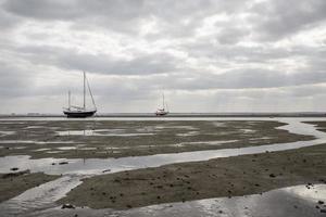 Fischerboote stecken bei Ebbe am Strand fest. foto