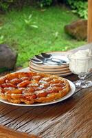 Tarte tartin mit Platten und Besteck auf das Tabelle foto