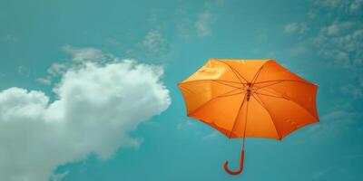 hell Orange Regenschirm schwebend gegen ein Blau Himmel mit Wolken foto