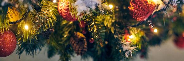 Weihnachten Baum Glühbirnen mit Gelb Girlanden bedeckt Schnee, draussen Weihnachten Baum mit dekorativ rot Glühbirnen foto