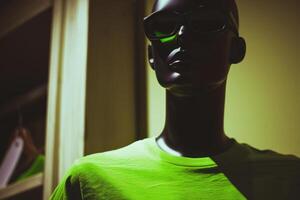 modern Mannequin im Sonnenbrille und beschwingt Grün Tee mit dramatisch Schatten foto