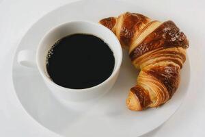 schwarz Kaffee und Croissant auf Weiß Hintergrund foto