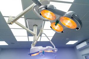 zwei chirurgisch Lampen im Betrieb Zimmer. Blau Besetzung Licht vertreten Reinheit und klinisch Stimmung. Datei zum Krankenhaus Broschüre oder medizinisch Artikel. foto