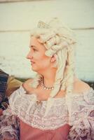 Porträt von blond Frau gekleidet im historisch Barock Kleider mit alt Mode Frisur foto