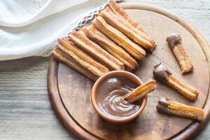 Churros - - berühmt Spanisch Dessert mit Schokolade Soße foto