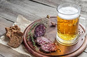 Scheiben französische Saucissonwurst mit einem Glas Bier foto