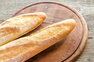 zwei Baguettes auf dem Holztablett foto