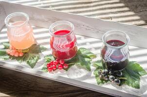 Johannisbeere Marmelade mit frisch Beeren auf das hölzern Tablett foto