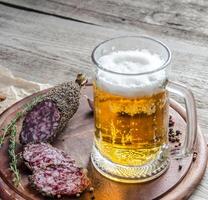 Scheiben französische Saucissonwurst mit einem Glas Bier foto