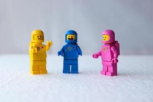 drei Lego Astronauten haben ein Diskussion während Stehen auf ein Weiß Hintergrund. foto