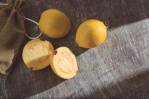 gelbe Guave auf hölzernem Hintergrund. Vitamin C, gesunde Obstdiät. foto