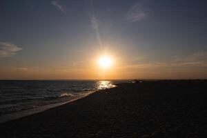 schön Sonnenuntergang auf ein sandig Strand in der Nähe von das Ozean. großartig Hintergrund zum Design foto