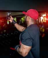 Lebensstil stark Bodybuilder mit Athlet Torso. muskulös gut aussehend afro Mann im das Fitnessstudio. foto