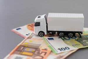 Weiß Spielzeug LKW auf Euro Banknoten. Konzept zum Logistik, Transport und und Finanzen foto