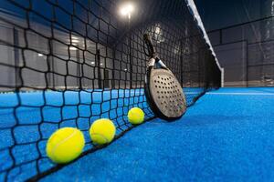 mehrere Bälle durch das Netz auf ein Blau Paddel Tennis Gericht foto