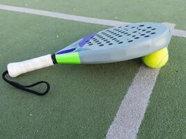 Hintergrund von Padel Schläger und Ball auf künstlich Gras Fußboden im draussen Gericht. oben Sicht. foto