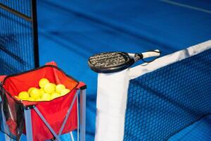 schwarz Fachmann Paddel Tennis Schläger und Ball mit natürlich Beleuchtung auf Blau Hintergrund. horizontal Sport Thema Poster, Gruß Karten, Überschriften, Webseite und App foto