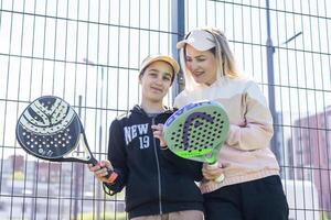 Ukraine Kiew, April 20 2024. Porträt von lächelnd Frau Paddel Tennis Spieler während Paar Spiel beim Gericht foto