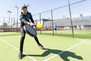 Mann spielen Paddel Tennis beim drinnen Tonhöhe foto