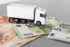 Weiß Spielzeug LKW auf Euro Banknoten. Konzept zum Logistik, Transport und und Finanzen foto