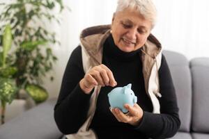 Senior Frau halten Schweinchen Bank foto