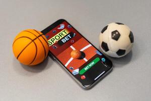 Smartphone mit Anwendung zum Sport Wetten und ein Basketball Ball, Konzept von online Wetten foto